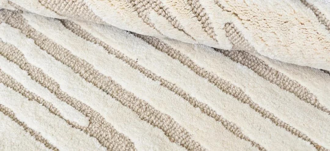 Close-up of the Dune rug folded over, showing its wool and silk pile