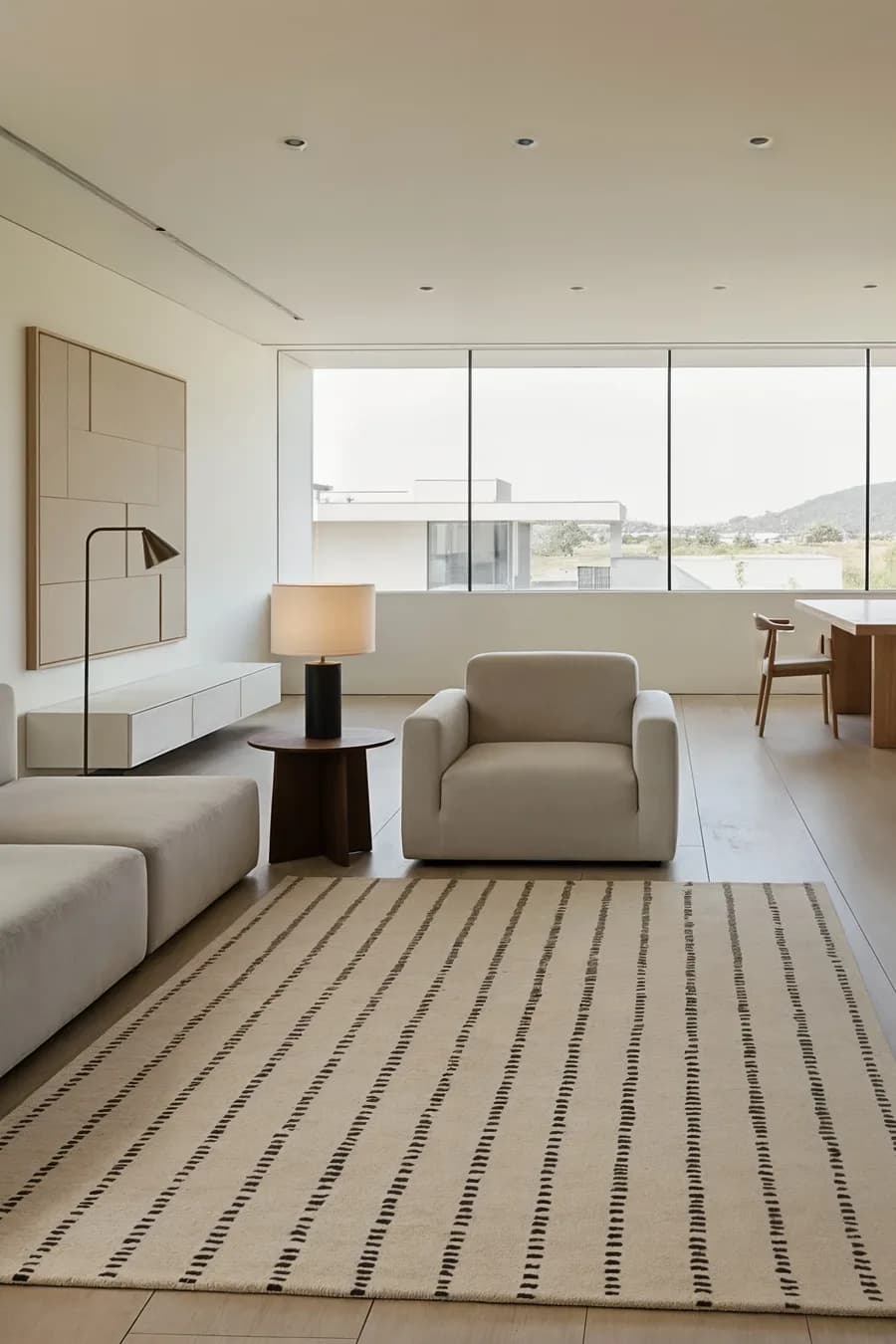 The Greige rug, cream with broken charcoal stripes, in a bright minimal living room