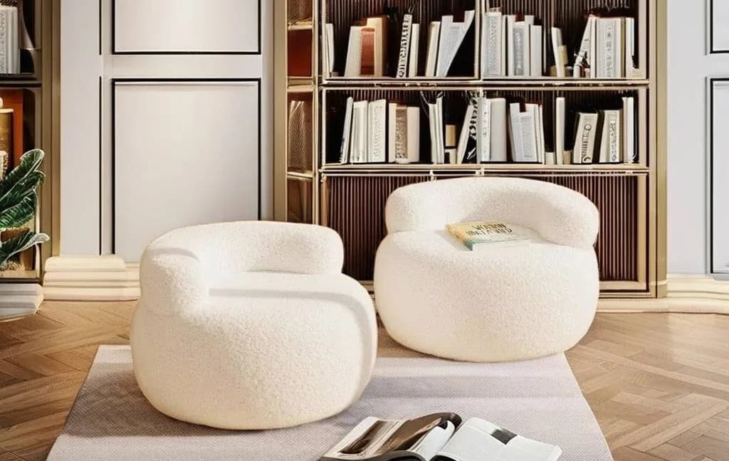 Two Brady bouclé chairs on a rug in front of a bookcase